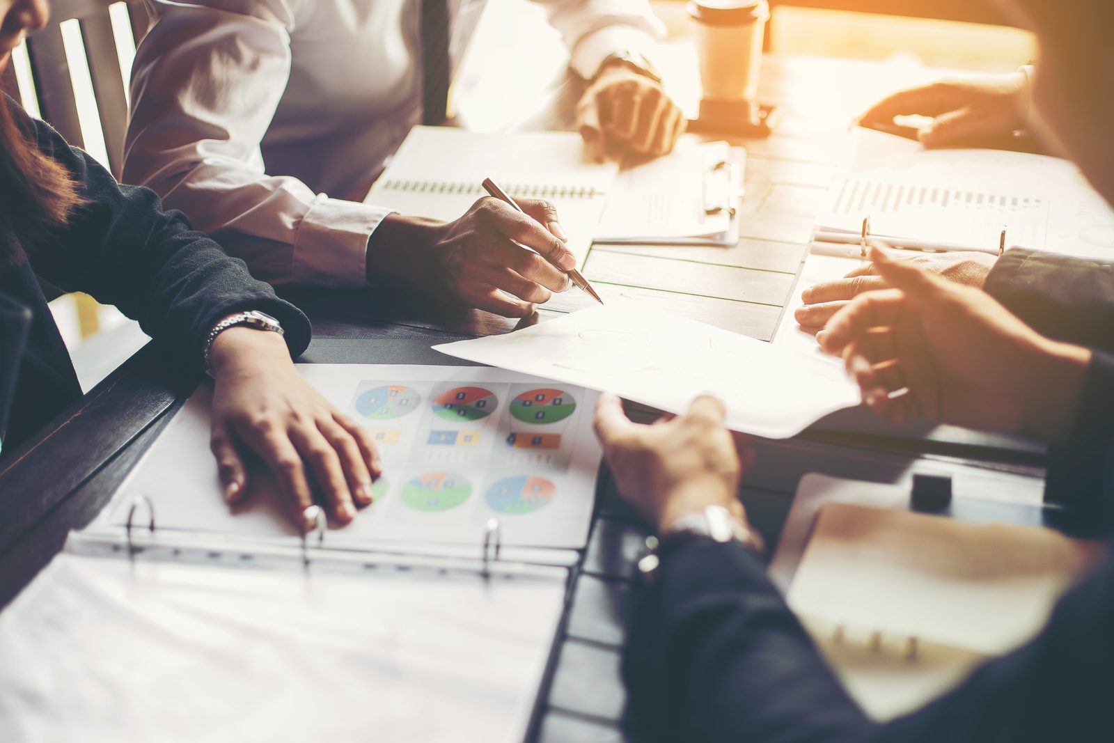 People sitting at a table using their paperwork to discuss a project